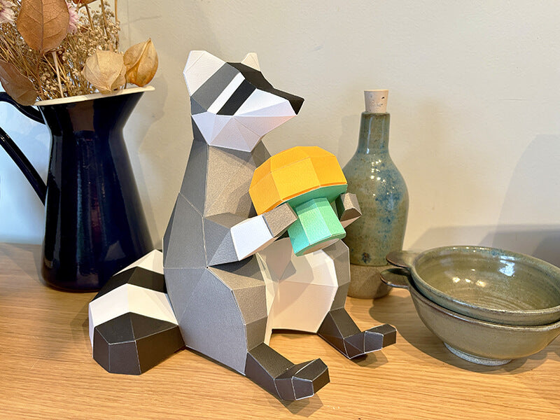 a papercraft raccoon 3D puzzle holding a papercraft mushroom